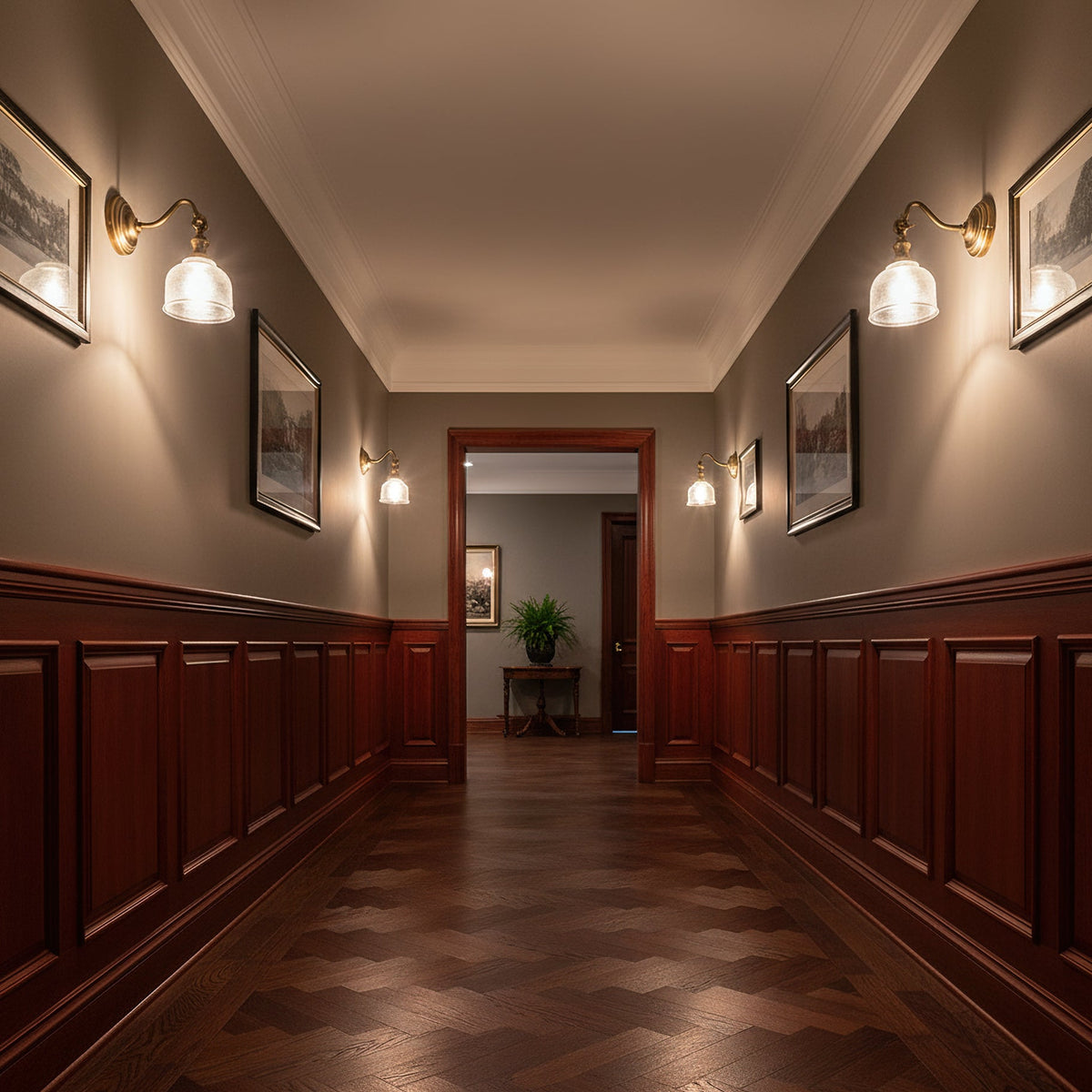 Clérachic brass wall lights with glass shades line both sides of a long hallway with dark wood panelling and a parquet floor.