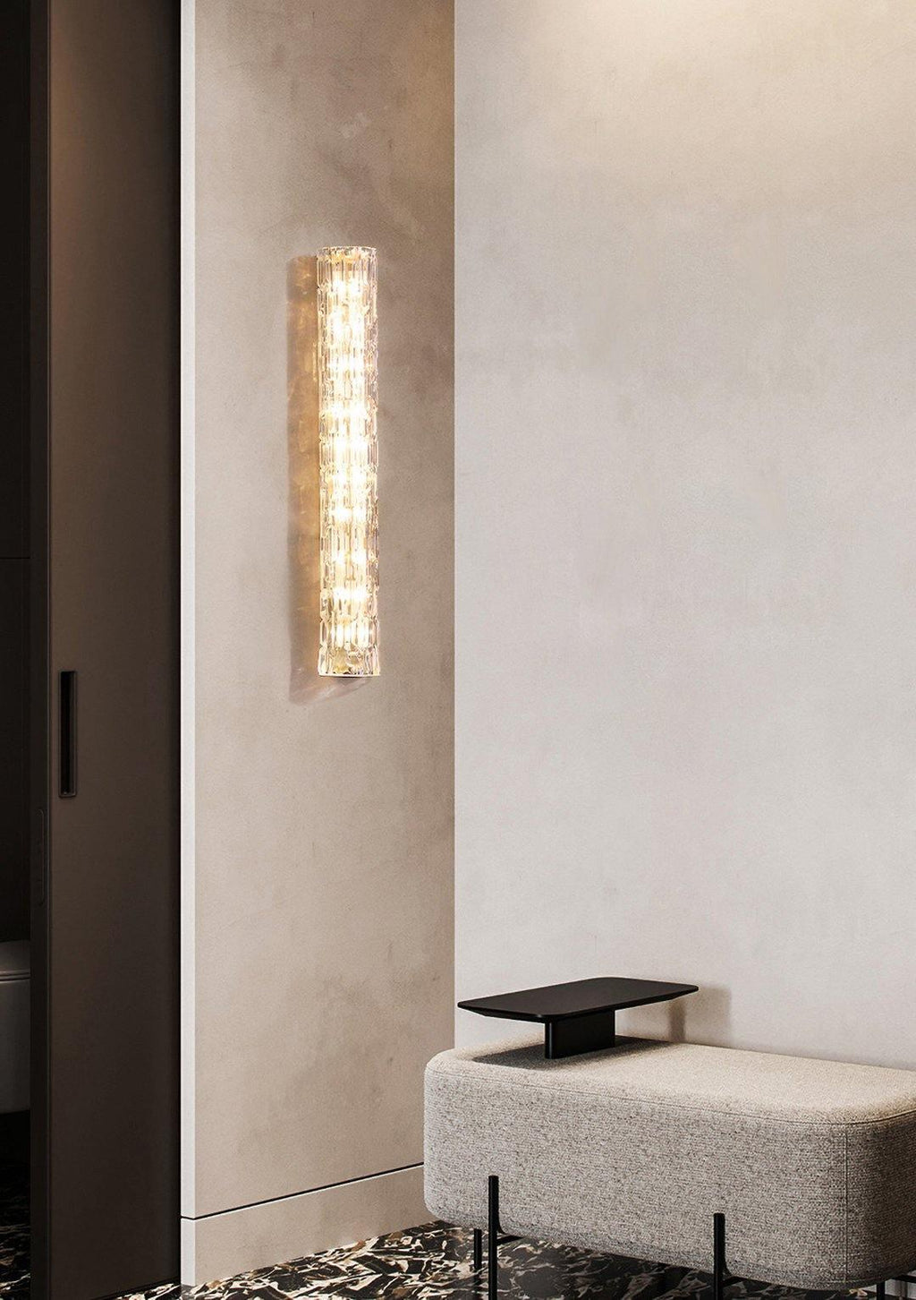 Clérachic glass wall light on a pale plaster wall by a dark doorway, with a low grey upholstered bench beneath.