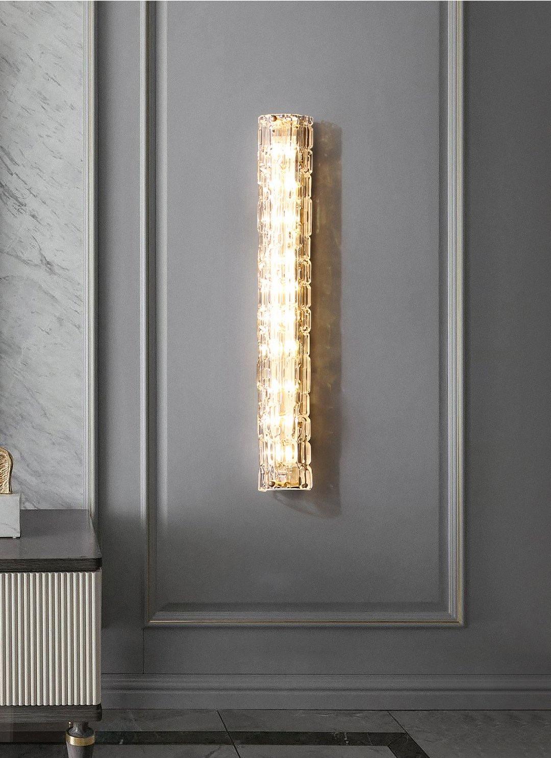 Clérachic wall sconce centred on a grey panelled wall, with a marble-effect wall and a fluted cabinet to the left.