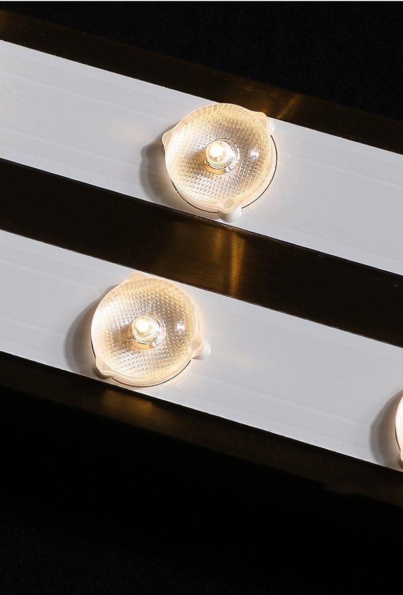 Close view of the LED strip inside this Clérachic wall light, with round lenses on white boards and a gold-toned backplate.