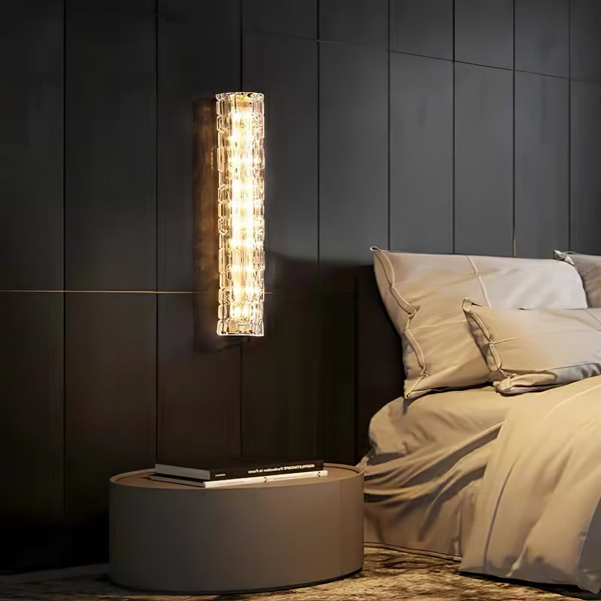 Lit Clérachic wall light on dark wood panelling, with a round bedside table and a bed in rumpled beige linen.