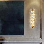 Clérachic wall light lit beside a large dark blue textured canvas on a grey panelled wall.