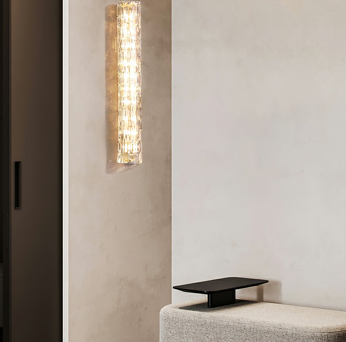 Clérachic glass wall light high on a beige wall beside a dark door, above the edge of a low grey bench.