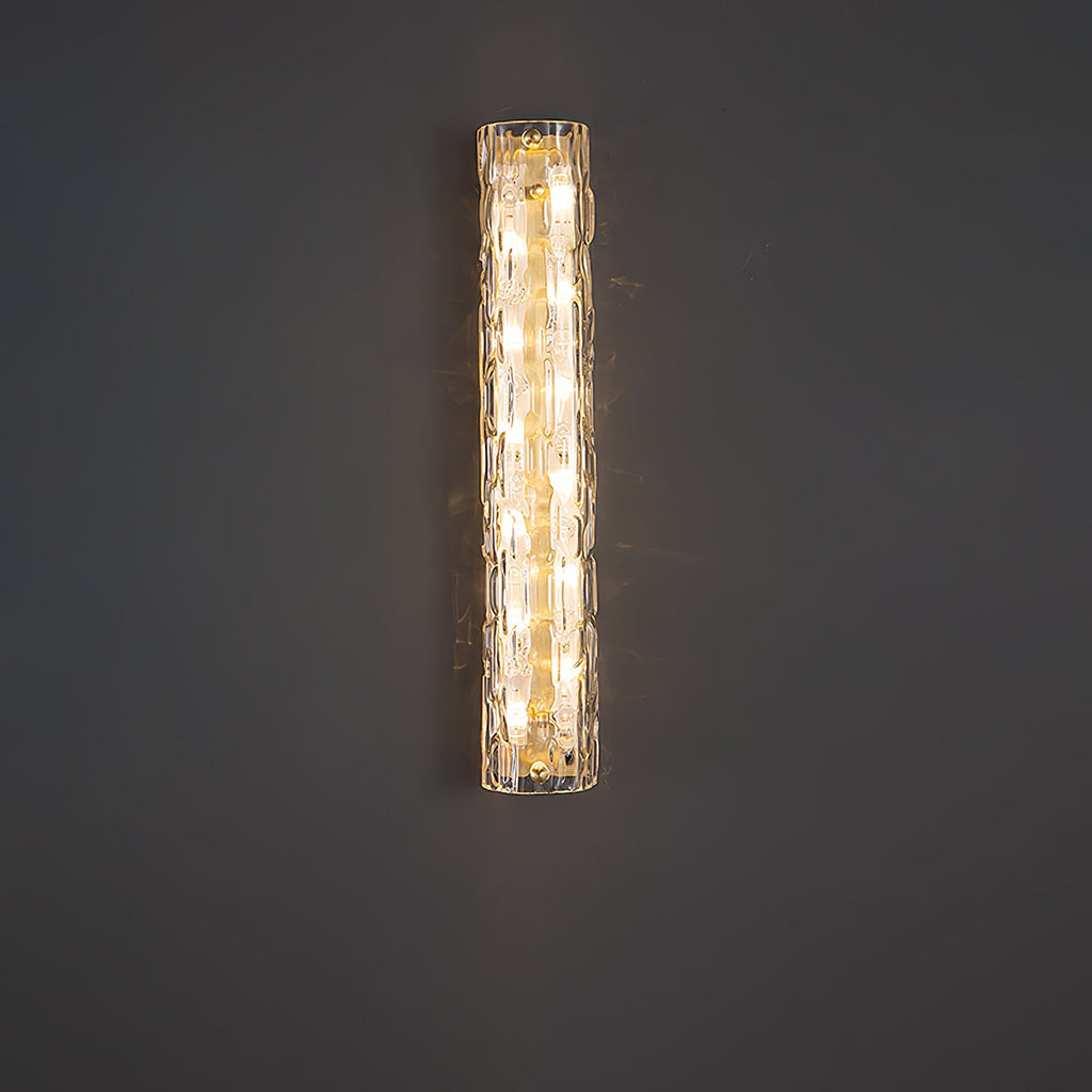 Clérachic glass wall light lit against a plain dark grey wall, its warm bulbs showing through the textured shade.