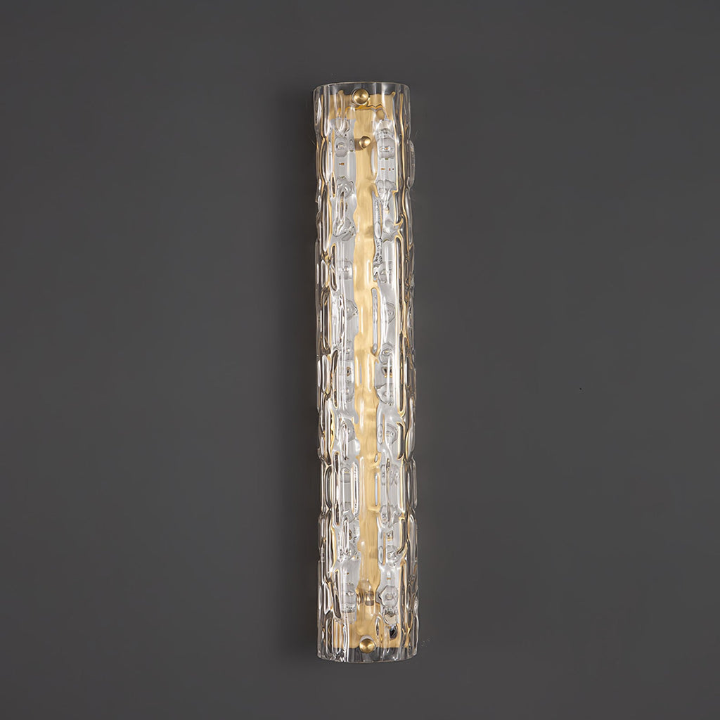 Unlit Clérachic wall light on a dark grey wall, showing clear rippled glass over a brushed gold backplate.