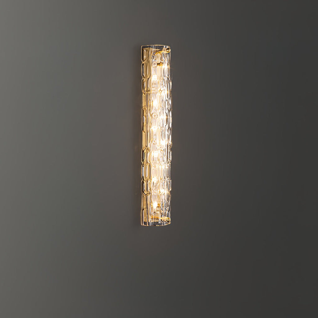 Lit Clérachic wall light on a dark grey wall, with its warm light showing through the textured glass.