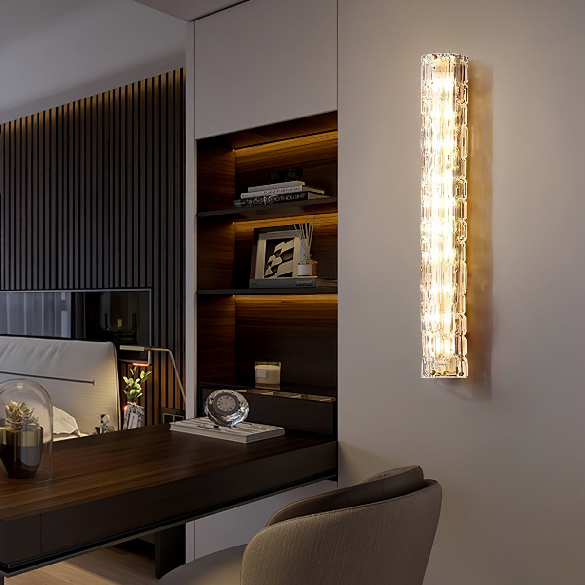 A Clérachic wall light glows beside a bookshelf with lit shelves and a dark desk with a leather chair.