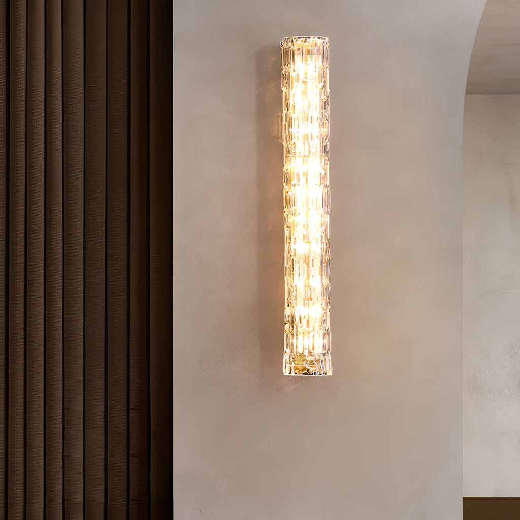 Clérachic glass wall light lit on a plaster wall beside a brown ribbed curtain.