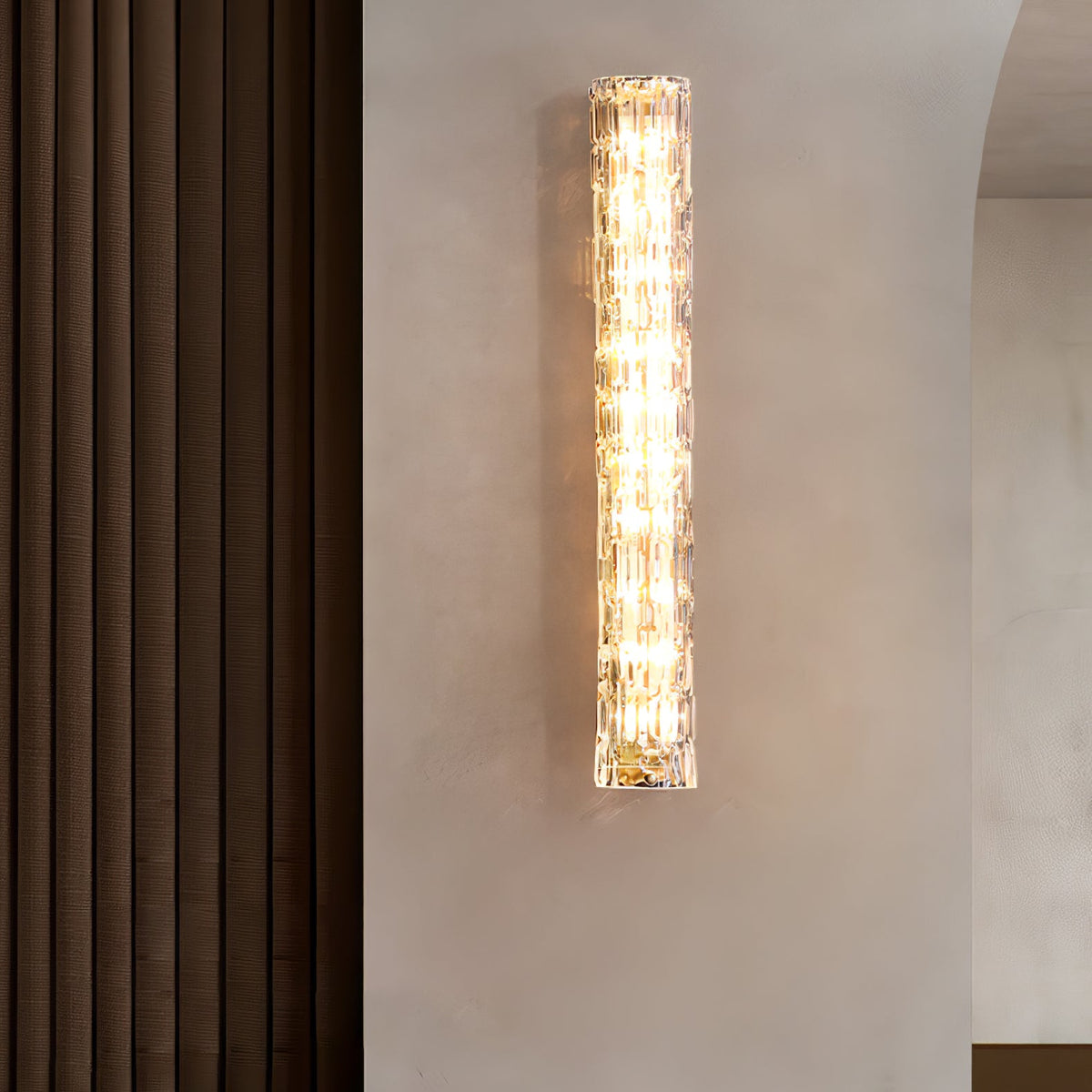 Clérachic glass wall light lit on a plaster wall beside a brown ribbed curtain.
