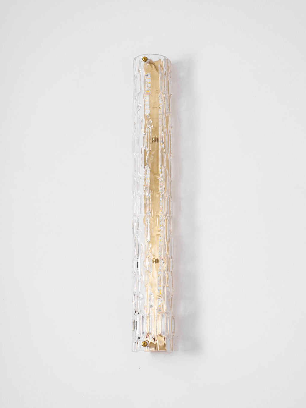 Unlit Clérachic wall light on a pale wall, its clear rippled glass wide over a gold backplate.