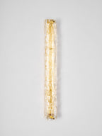 Clérachic wall light lit on a pale wall, a narrow column of warm light behind the textured glass.