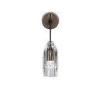 A dark bronze-toned version of this Clérachic wall light on white, with a clear faceted crystal shade and a slim black arm.