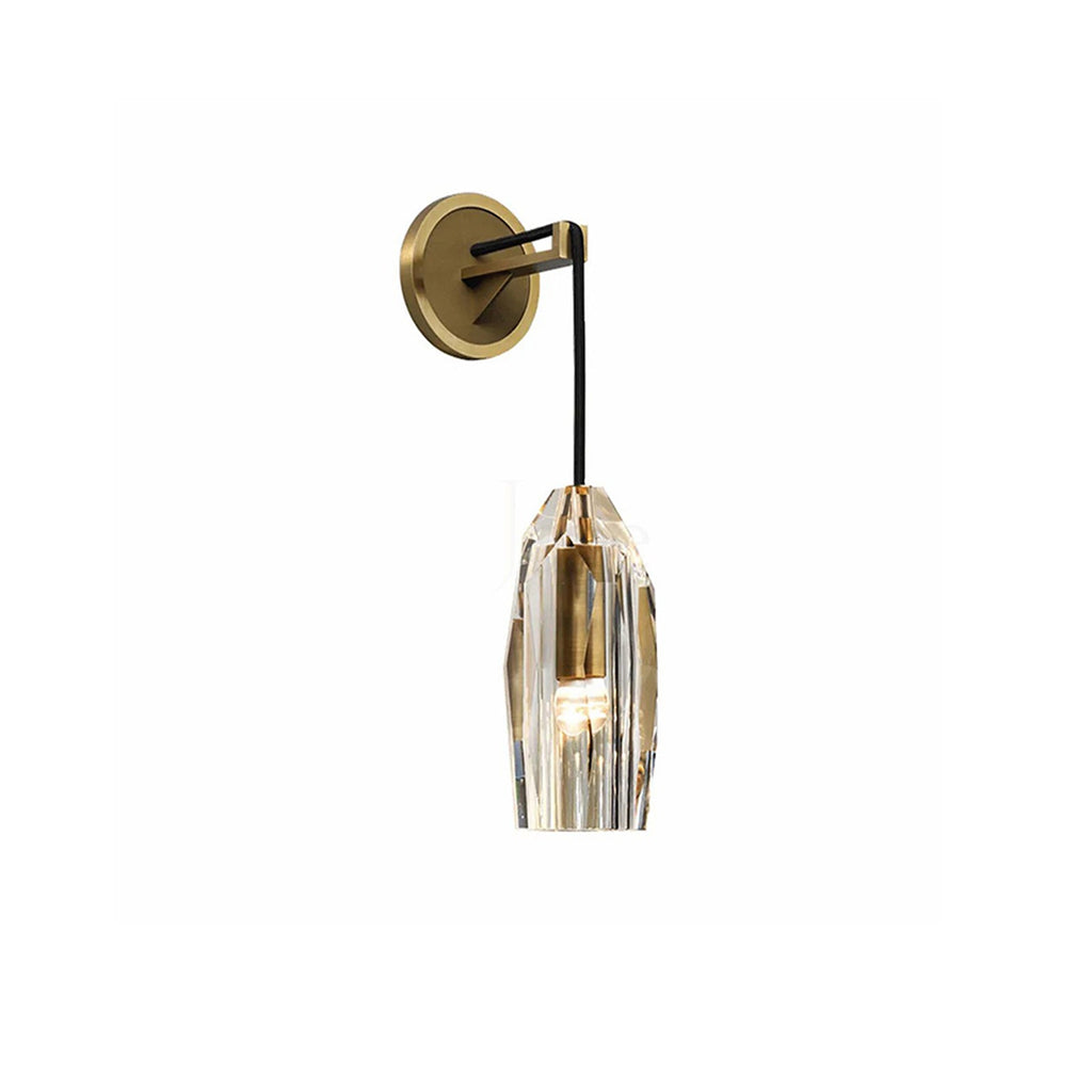 A Clérachic brass wall light on a white backdrop, the faceted crystal shade glowing warm under a round plate and black cord arm.