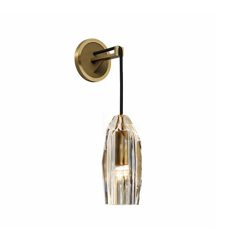 A Clérachic wall light in brass on a white backdrop, with its black cord arm, round plate and a faceted crystal shade.