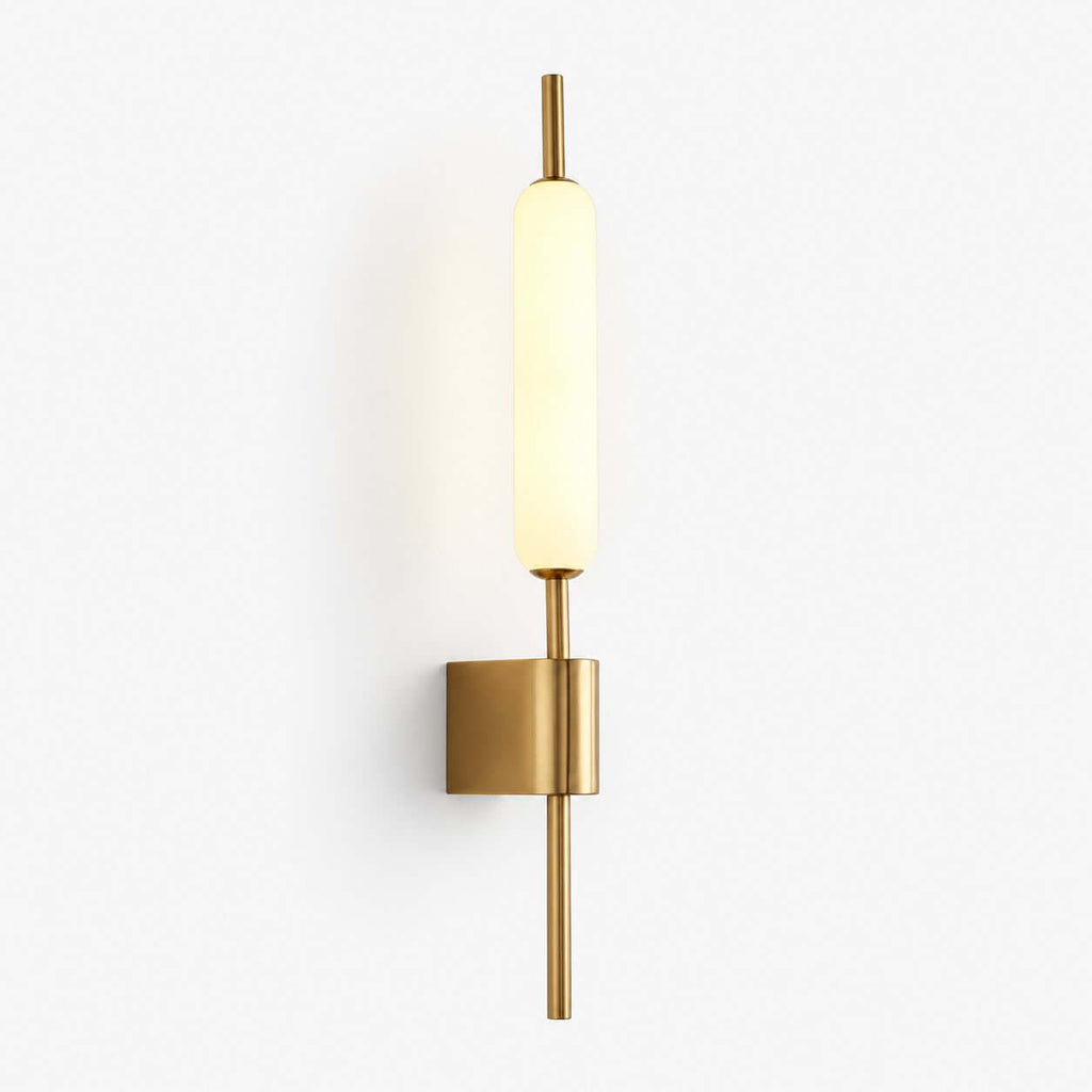 Slim brass wall sconce from Clérachic with a frosted glass tube, lit warm white on a plain white backdrop.