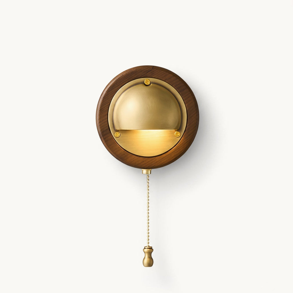 Round Clérachic wall light in Walnut & Brass, with a half-dome brass shade aimed downward and a beaded pull chain with a brass knob.