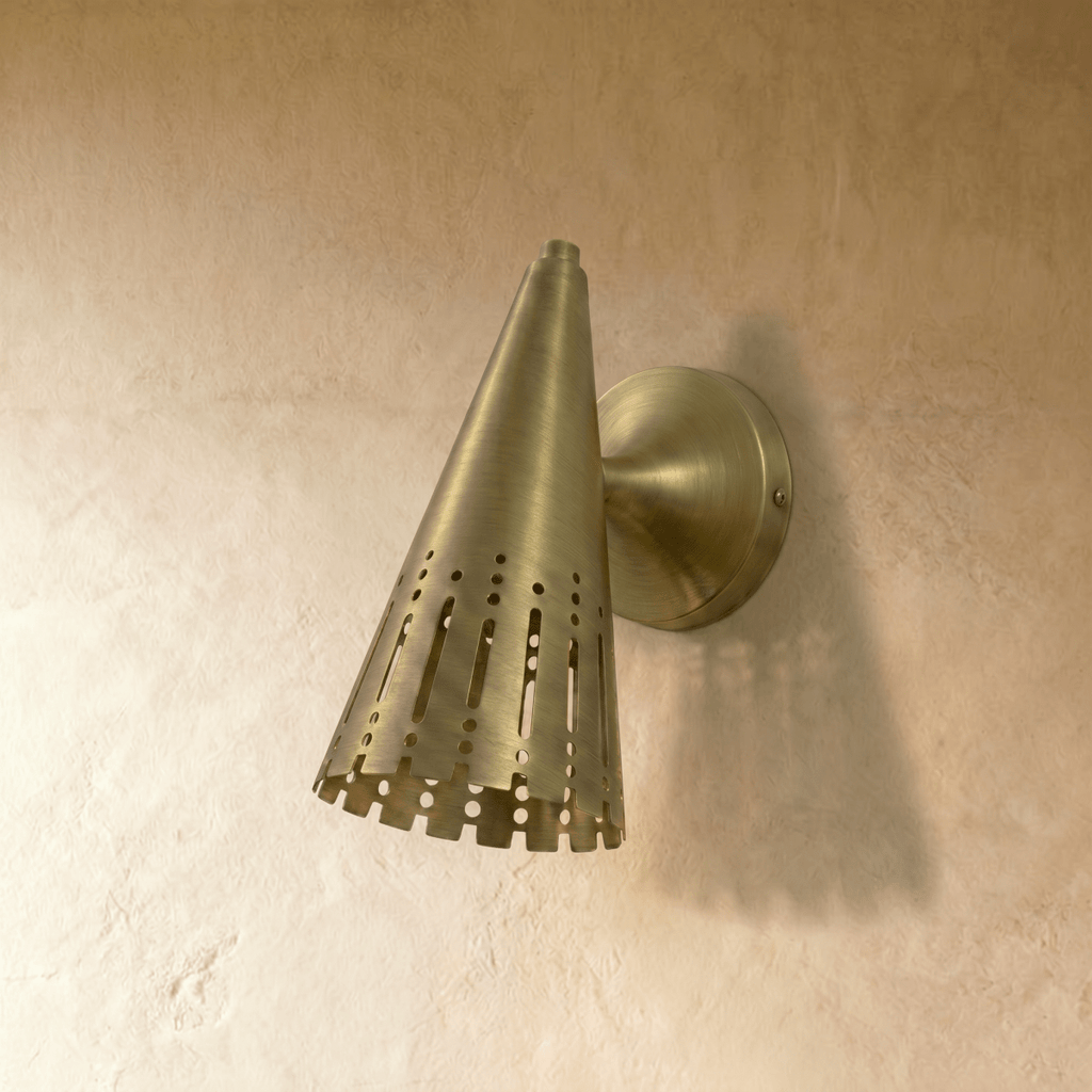 Clérachic wall lamp in brushed brass viewed from the side, showing the cone shade's rounded wall mount.