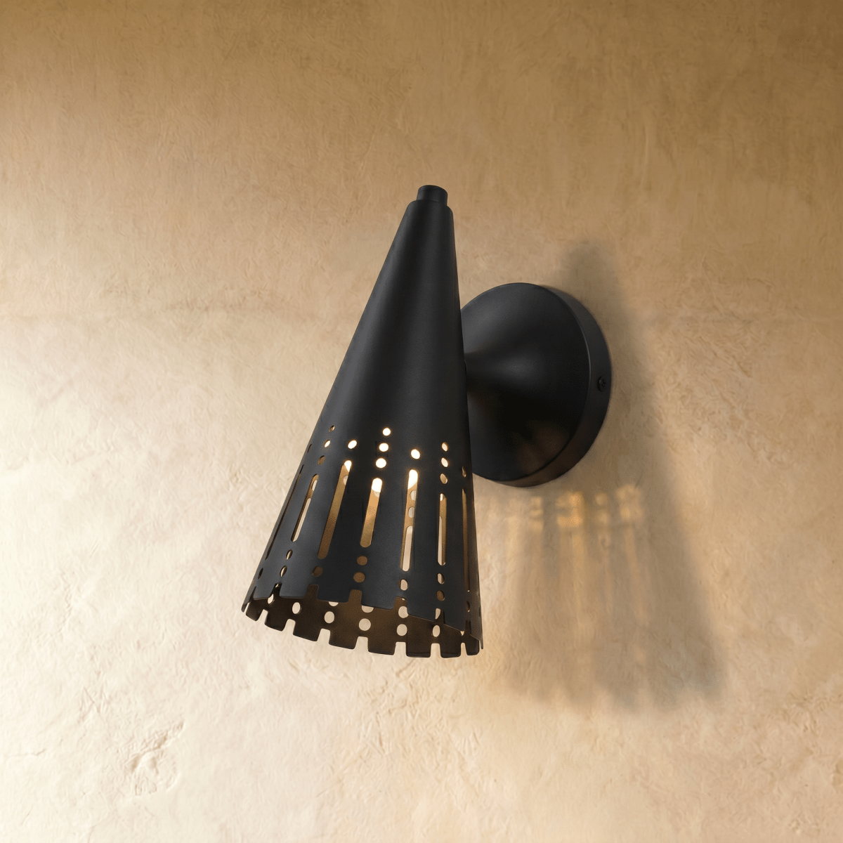 Clérachic wall lamp in matte black, a slotted cone shade throwing warm striped light across the wall.
