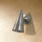 Clérachic wall lamp in chrome viewed close, its perforated shade casting fine vertical light lines.