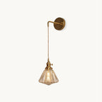 This Clérachic wall light on a plain white backdrop, with a curved brass arm, twisted cord and a ribbed glass shade.