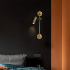 One lit spot head on a slim bronze rail, from Clérachic, hung on a dark wall above a bed with teal bedding, beside an orange wall.