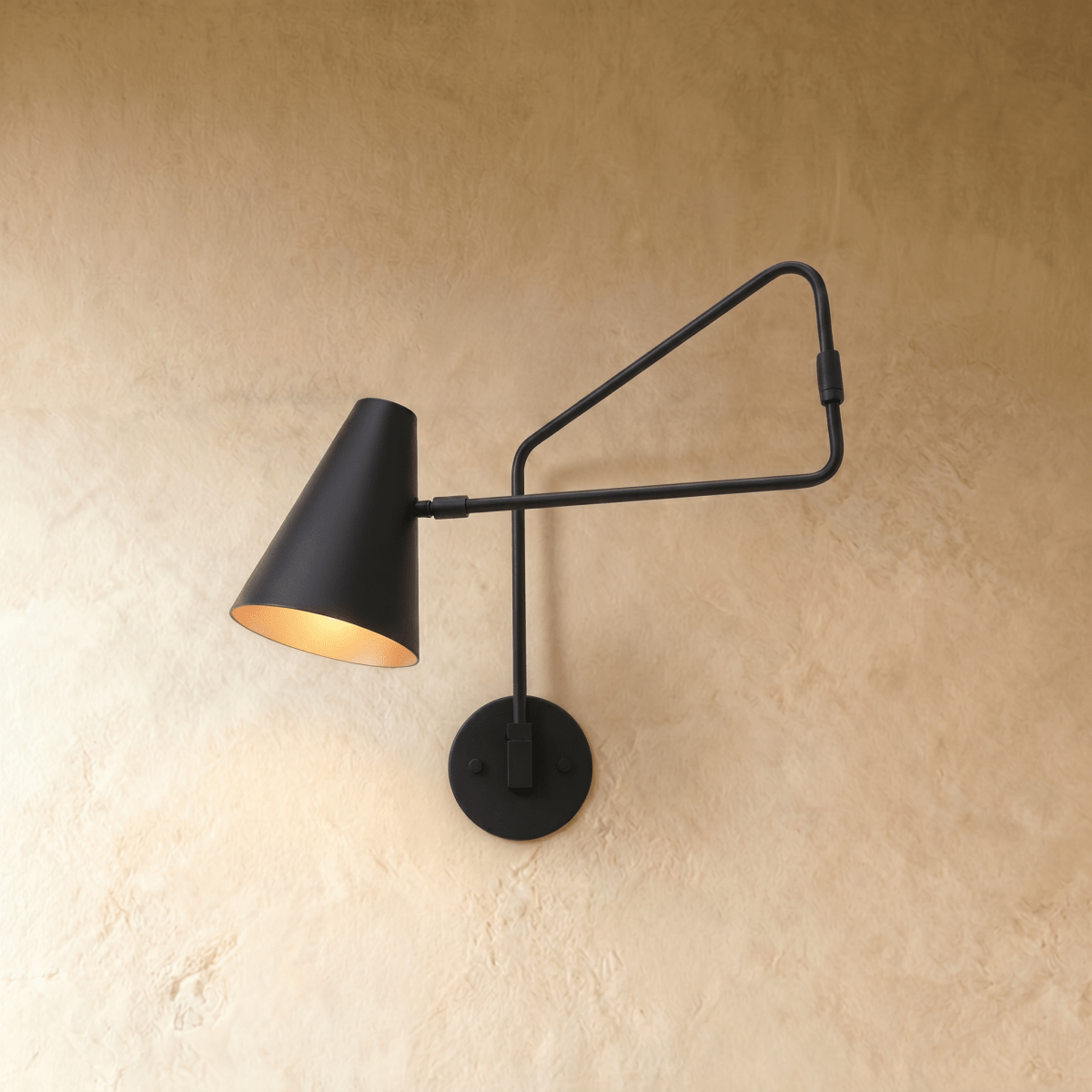 Clérachic wall lamp in matte black, a cone shade on an articulated swing arm against plaster.