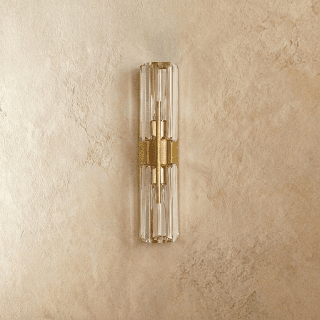 Clérachic brass wall lamp, switched off, with two stacked faceted clear crystal cylinders on a slim brass backplate.