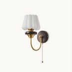 White fluted glass shade on a curved brass arm with a walnut-toned ring and round backplate, from Clérachic, with a ball-tipped pull chain.