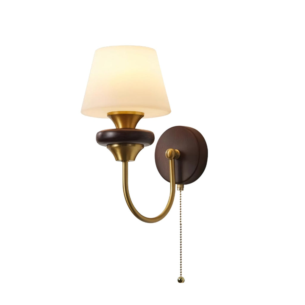 Clérachic wall lamp with a tapered white glass shade and a curved brass arm, shown with its pull chain on a white backdrop.