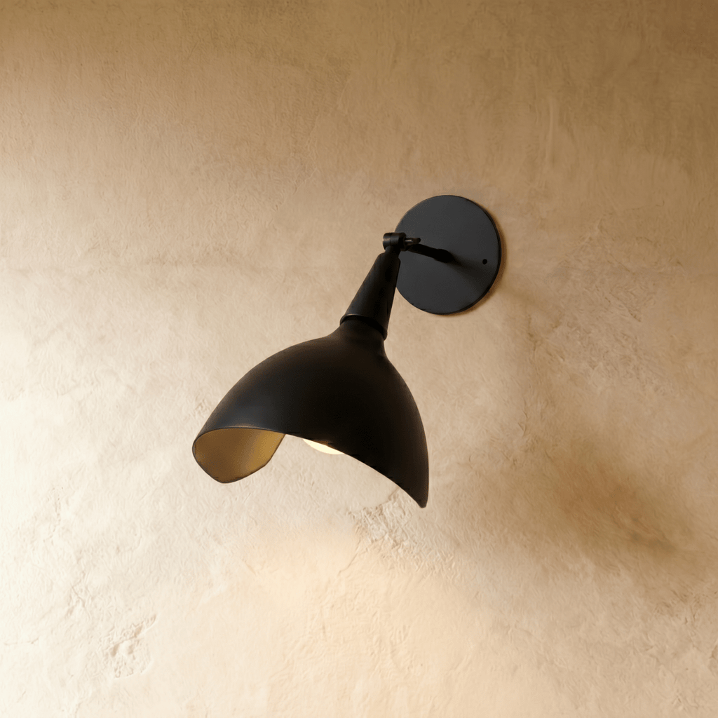 Clérachic wall lamp in matte black, a swiveling cone shade angled to direct light downward.