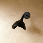 Clérachic wall lamp in matte black viewed close, showing the swivel joint and rounded wall plate.