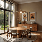 Clérachic brass pendant light glowing above a round dining table beside framed animal prints and glass doors.