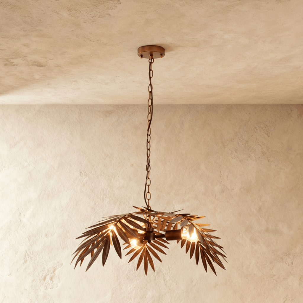 Clérachic bronze palm-leaf chandelier on a long chain, its iron fronds fanned around warm bulbs, on a limewash wall.
