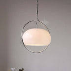 Clérachic cream glass dome pendant in a polished chrome ring, shown lit on a light-grey wall.