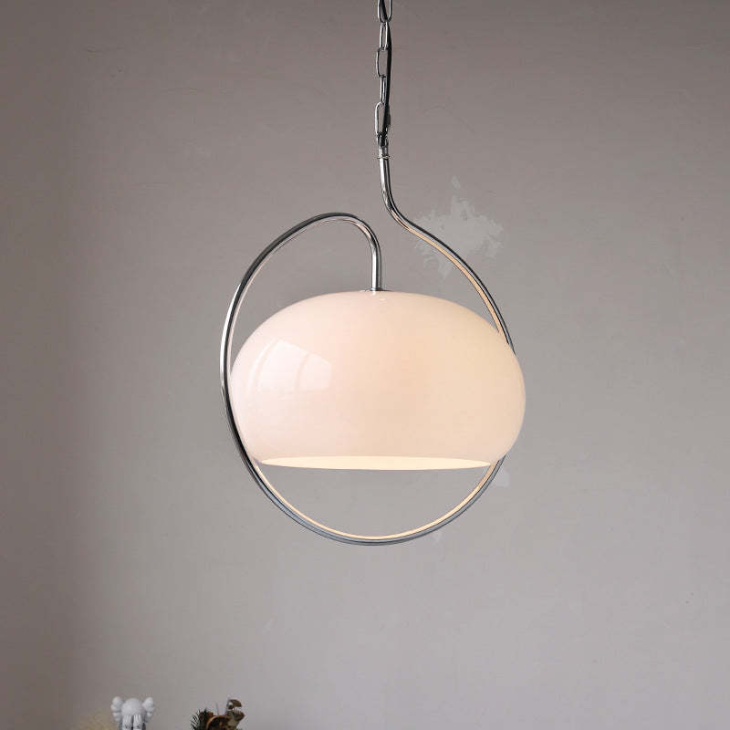 Clérachic cream glass dome pendant in a polished chrome ring, shown lit on a light-grey wall.