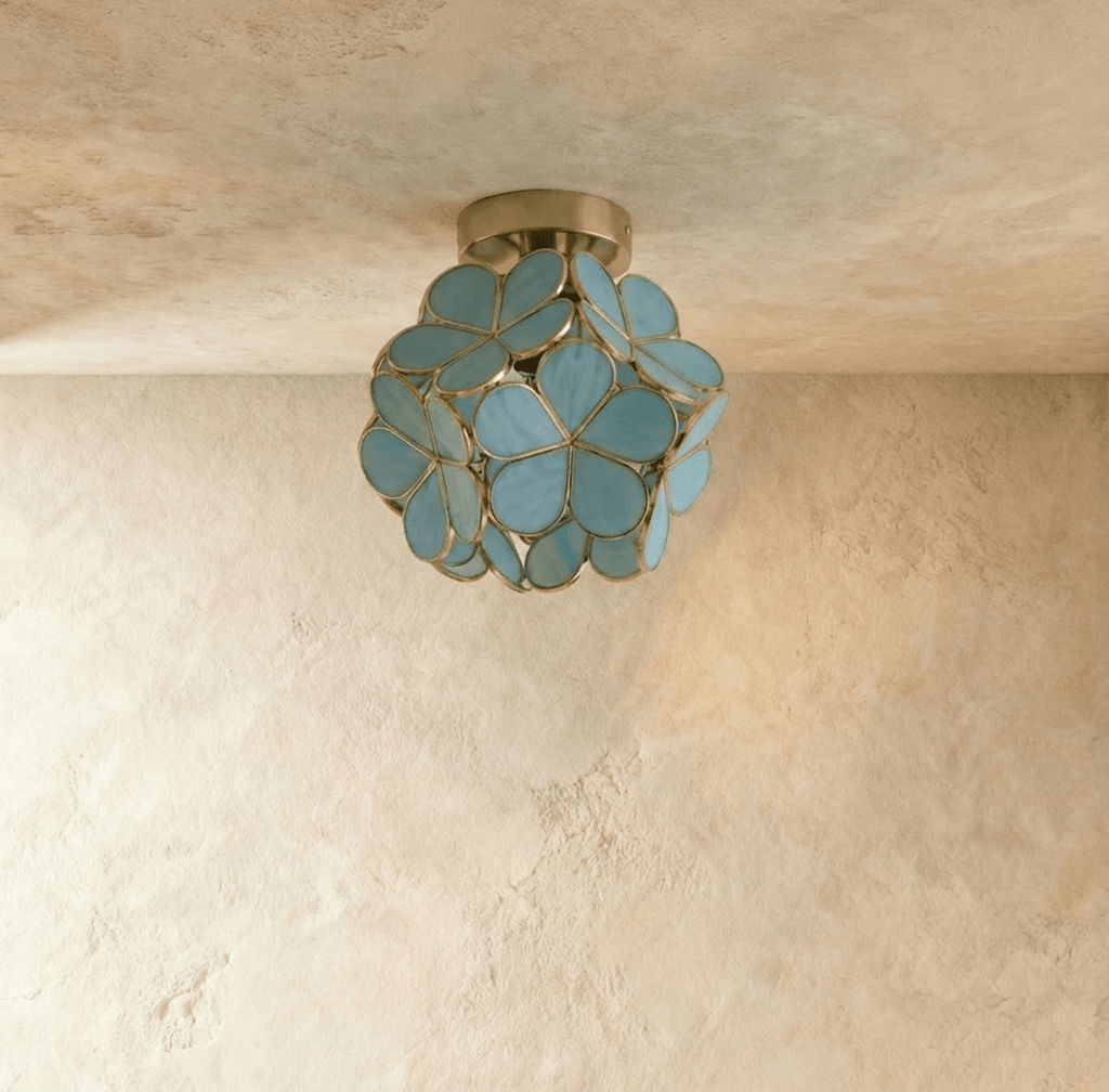 Clérachic flower ceiling light in teal-green glass petals on a nickel mount, casting a starburst shadow above.