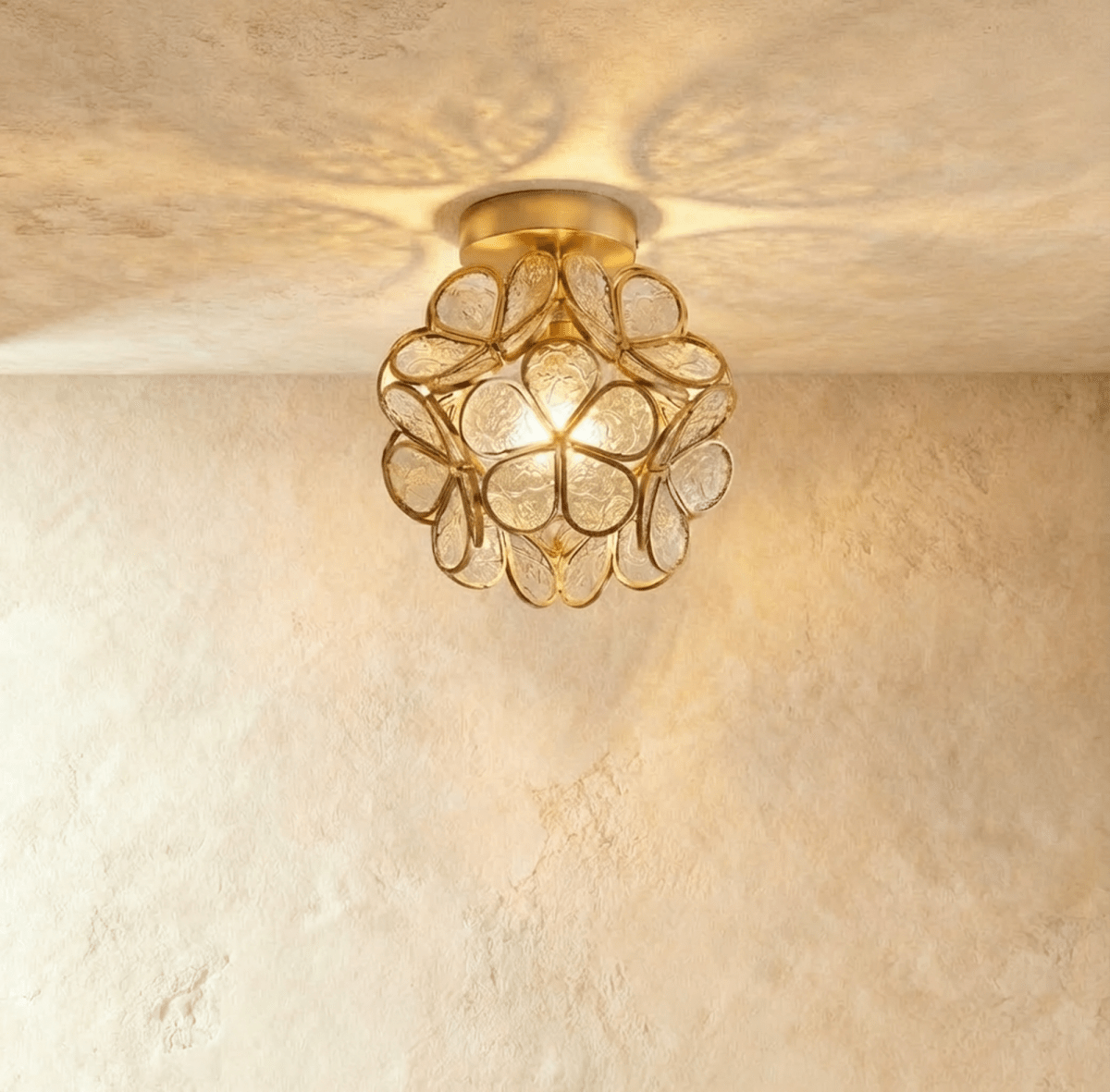 Clérachic flower ceiling light in clear glass petals with an embossed floral pattern, glowing bright and warm.