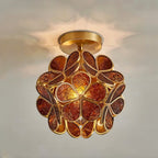 Clérachic flower ceiling light in deep amber glass petals with an embossed floral pattern, lit warm and close.