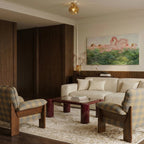 Clérachic flower ceiling light in warm amber glass glows above a living room with plaid armchairs.