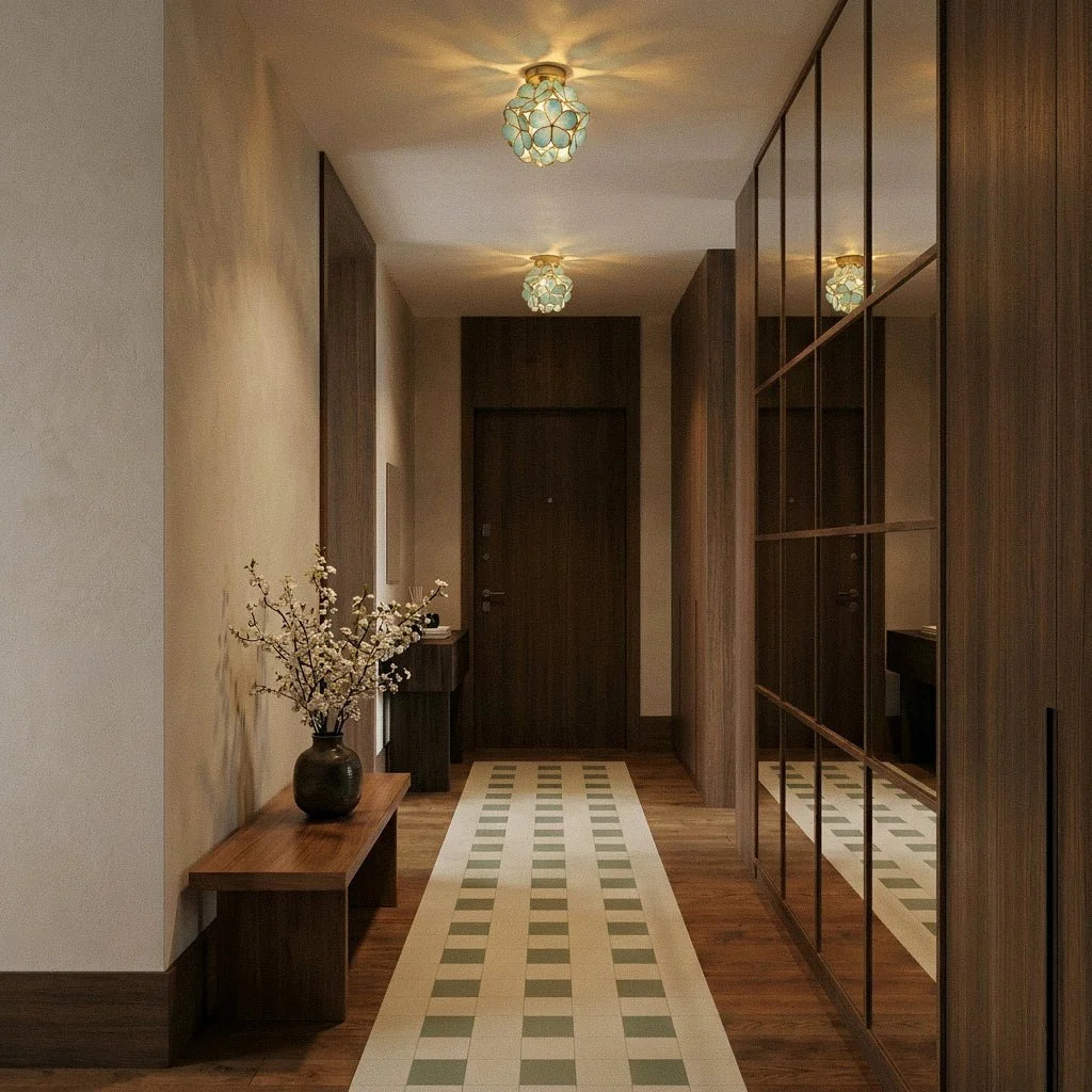 Two Clérachic flower ceiling lights in teal-green glass glow warm down a mirrored hallway runner.