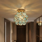 Clérachic flower ceiling light in teal-green glass petals glowing warm above a checkerboard hallway runner.