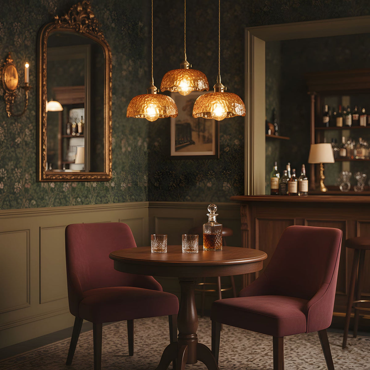 Three Clérachic brown glass pendants hung over a round wooden table with burgundy chairs, in a dark room with patterned green wallpaper.