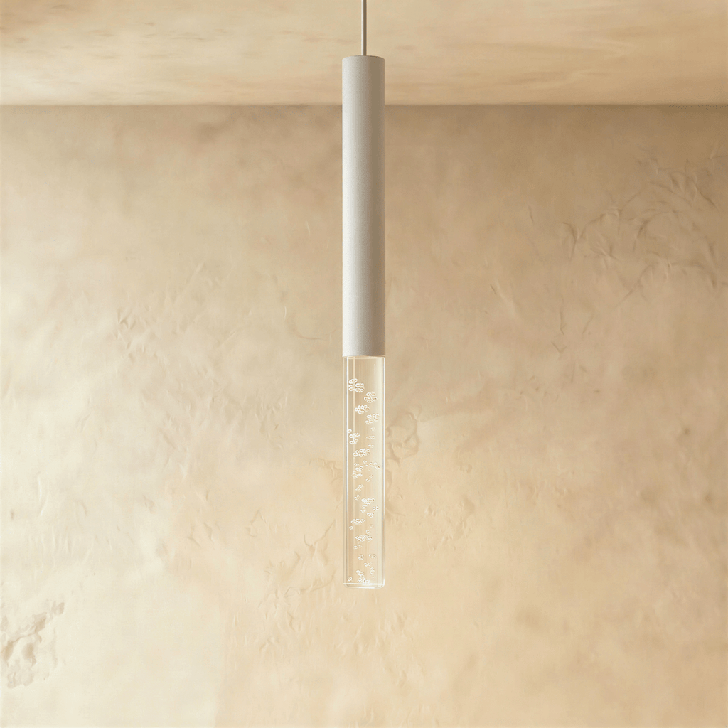 Clérachic slim white cylinder pendant with a clear acrylic shade of sparkling bubbles against a soft plaster wall.