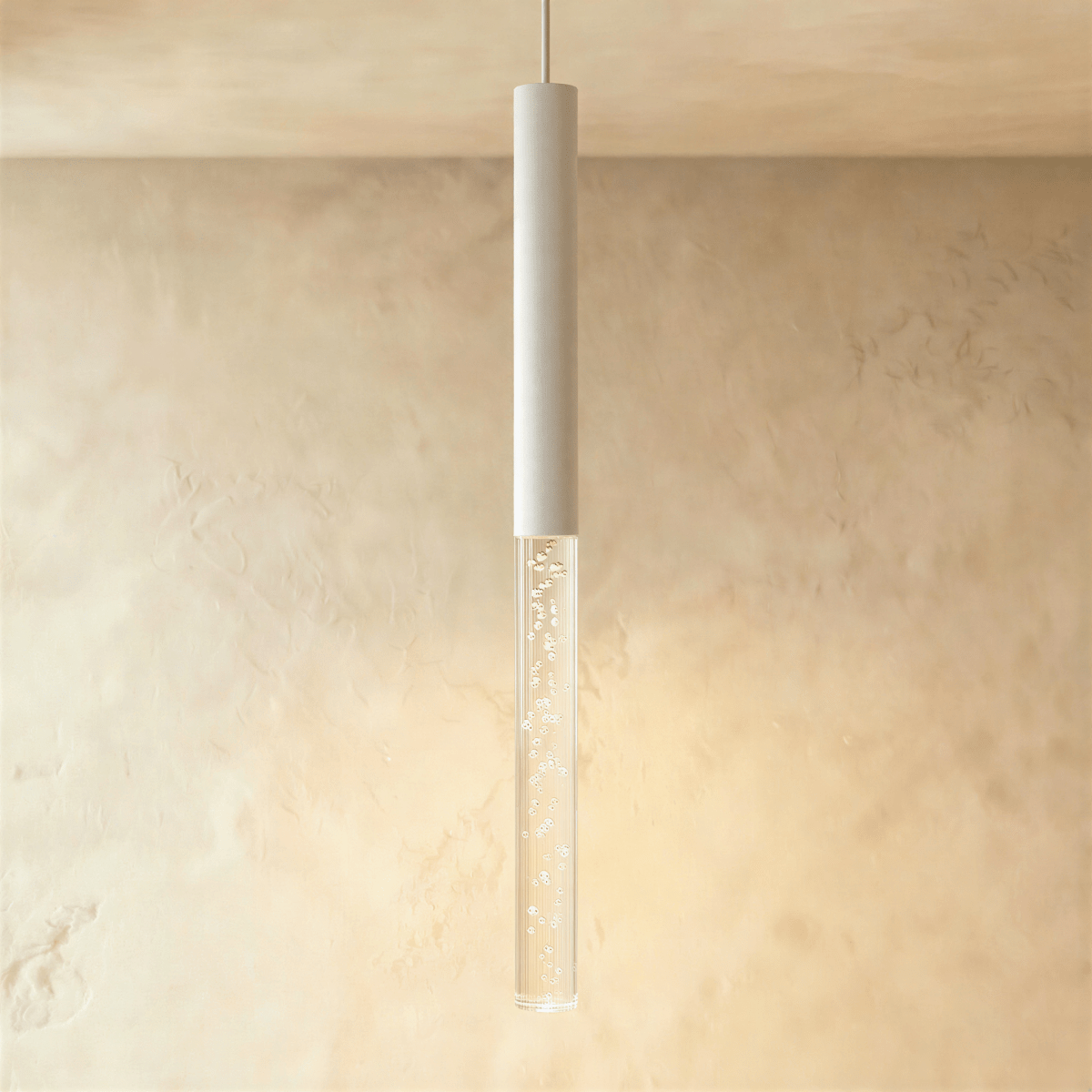 Clérachic white pendant light with the longest bubble acrylic shade, casting a warm glow on a limewash wall.