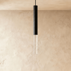 Clérachic black cylindrical pendant light with a short clear acrylic shade of fine bubbles, on a limewash wall.