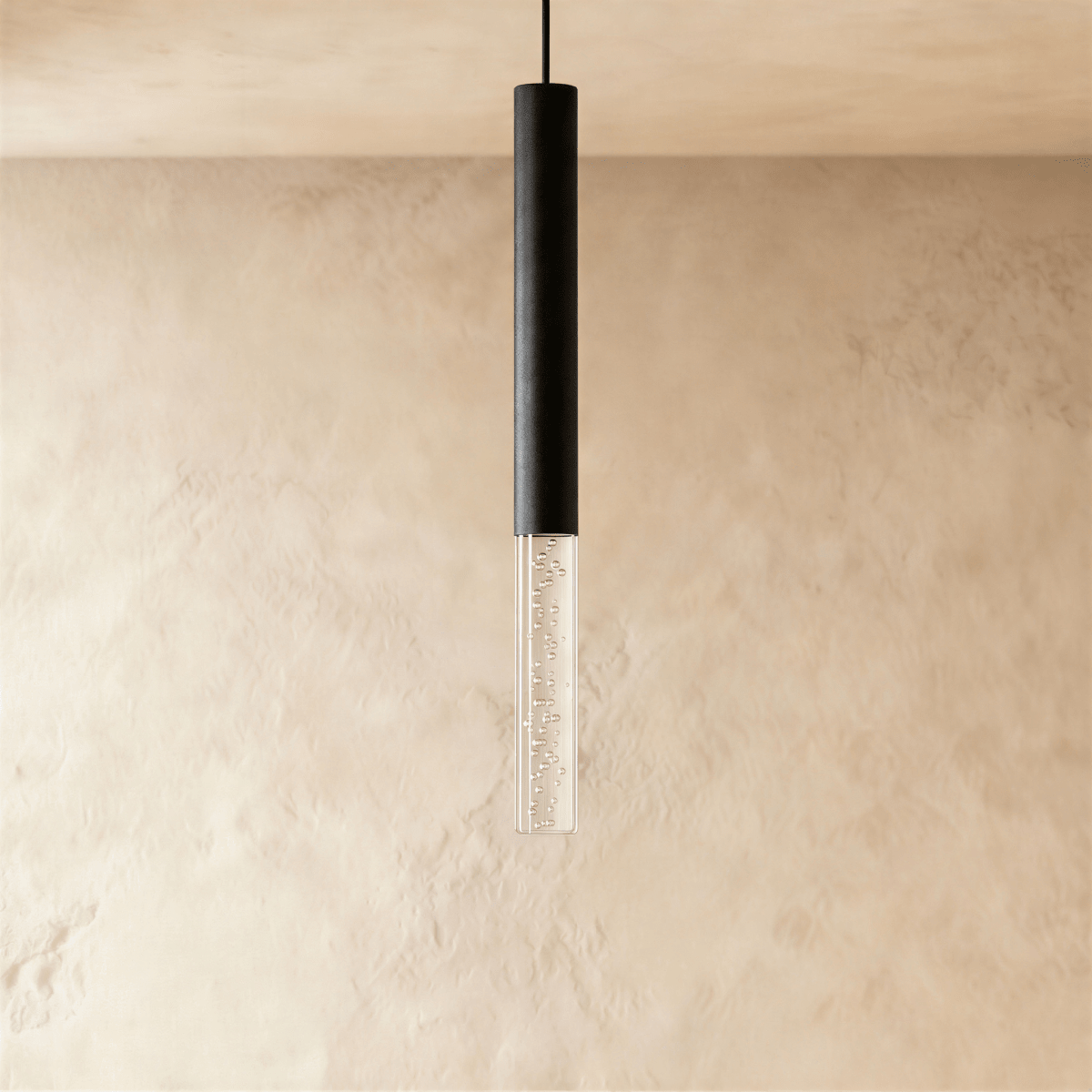 Clérachic black cylindrical pendant light with a short clear acrylic shade of fine bubbles, on a limewash wall.