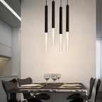 Four Clérachic black pendant lights with bubble acrylic shades hung at staggered heights above a dining table.
