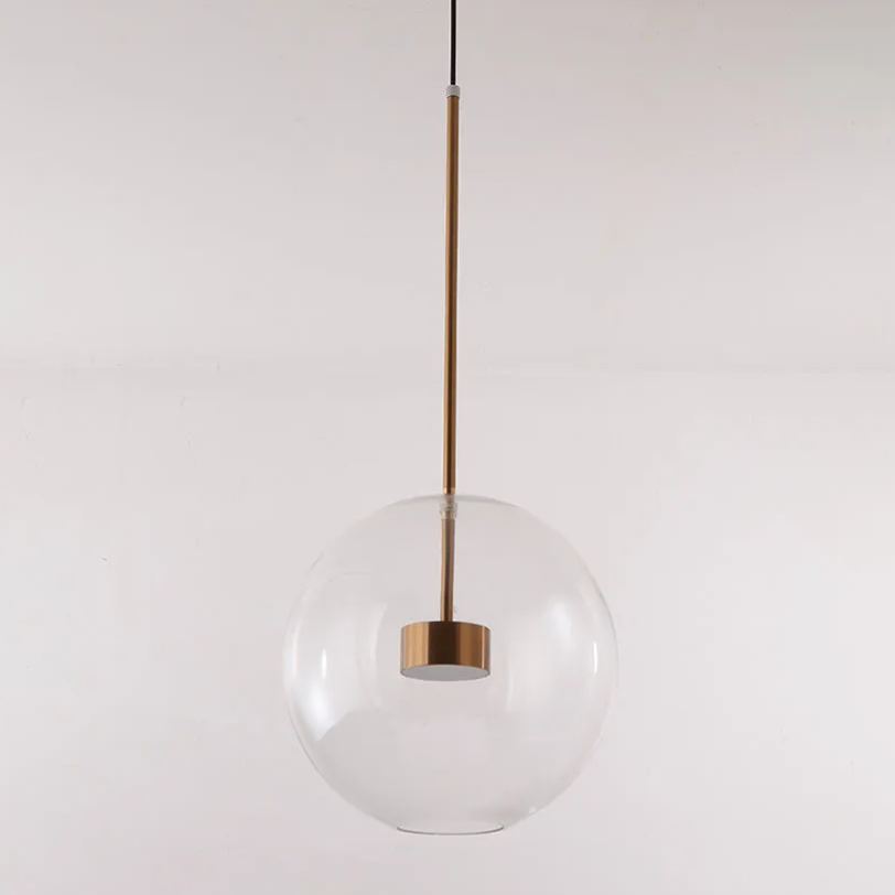 A single clear-glass globe of the Clérachic Bubble Cluster Pendant Light, its brass LED module visible through the glass.