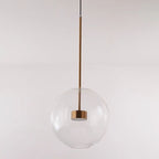 A single clear-glass globe of the Clérachic Bubble Cluster Pendant Light, its brass LED module visible through the glass.