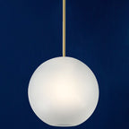 The Clérachic Bubble Cluster Pendant Light's frosted-glass globe glowing warm white against a deep navy wall.